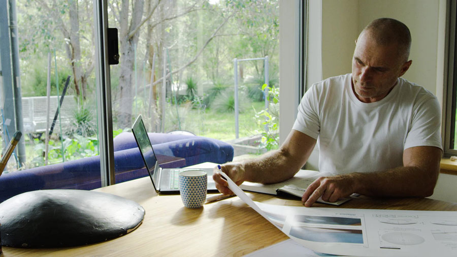 Troy at desk with drawings